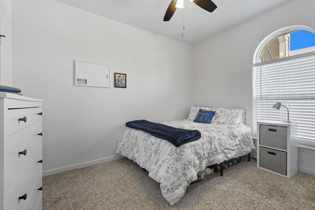 4430 Point Boulevard, Unit 203 Garland, TX 75043 - Photo 33 of 40 a bedroom with a bed and a ceiling fan