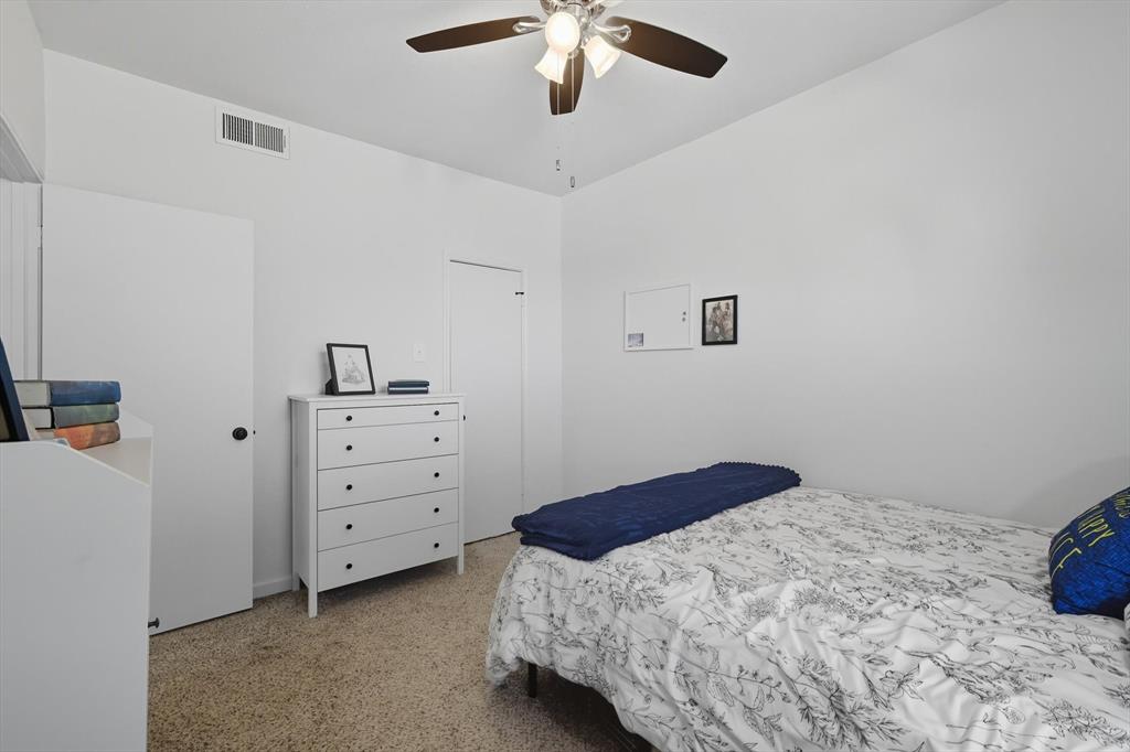 4430 Point Boulevard, Unit 203 Garland, TX 75043 - Photo 34 of 40 a bedroom with a bed and a chandelier