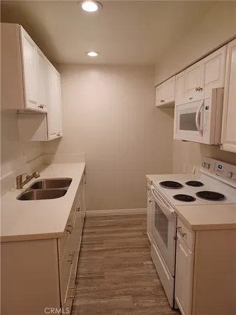 a kitchen with a stove sink and cabinets