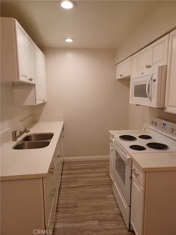 a kitchen with a stove sink and cabinets