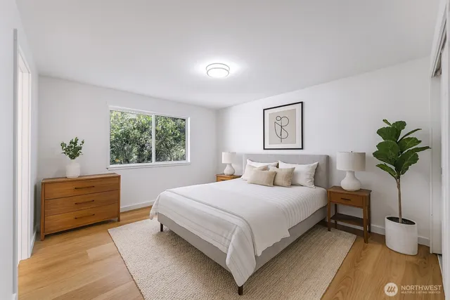 a bedroom with a large bed and a potted plant