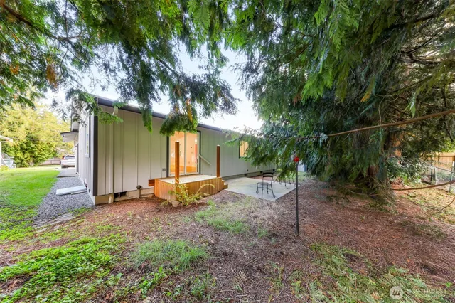 a view of a backyard with table and chairs and a large tree