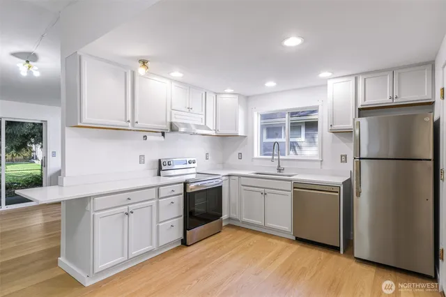 a kitchen with stainless steel appliances granite countertop a sink stove and refrigerator