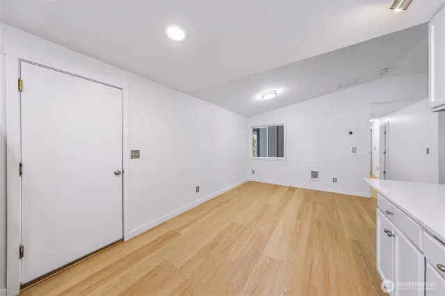 a view of a kitchen with wooden floor and natural light