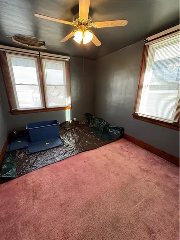 a view of an empty room with a chandelier fan