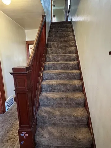 a view of an empty room with window and chandelier fan