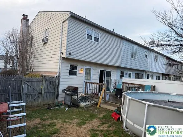 a view of house with backyard outdoor seating and barbeque oven