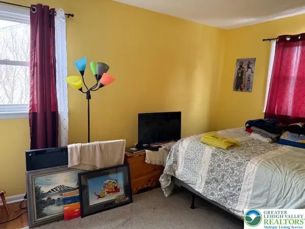 a bedroom with a bed and a flat screen tv