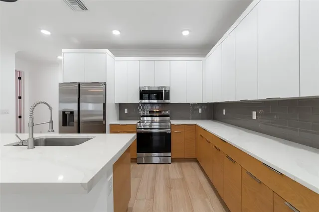 a kitchen with stainless steel appliances granite countertop a sink stove and refrigerator