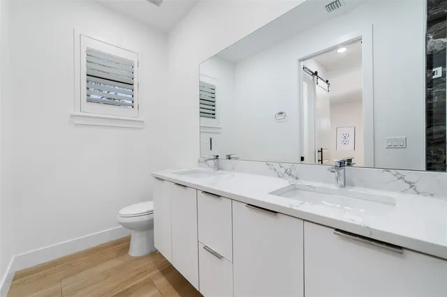 a bathroom with a granite countertop sink toilet and a mirror