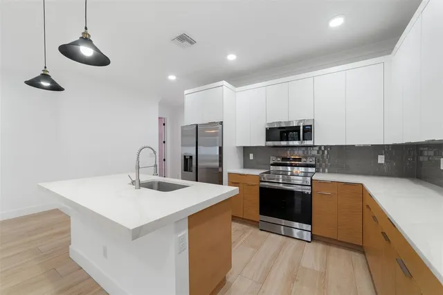 a kitchen with stainless steel appliances a sink stove and refrigerator