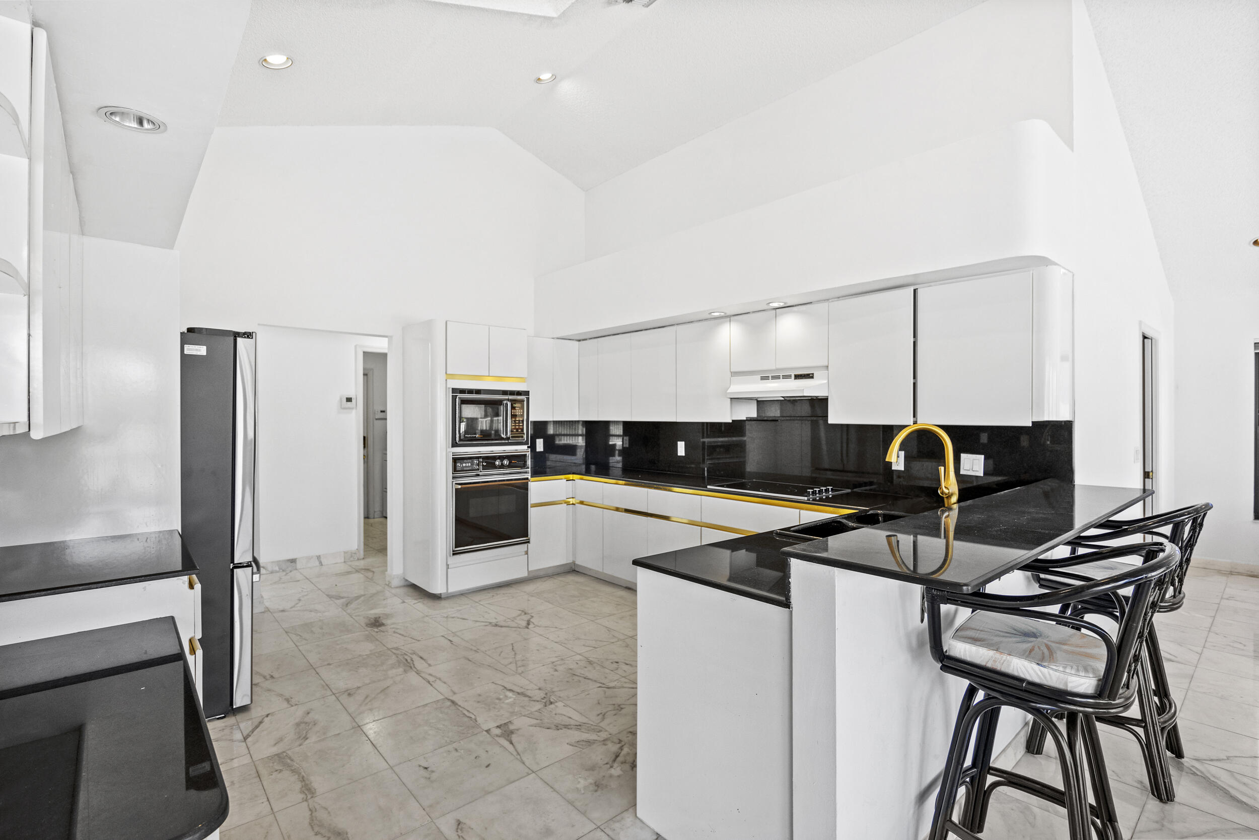 10747 Stonebridge Boulevard Boca Raton, FL 33498 - Photo 16 of 75 a kitchen with kitchen island a counter top space appliances and cabinets