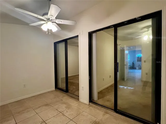 a view of a livingroom with a chandelier fan and a window