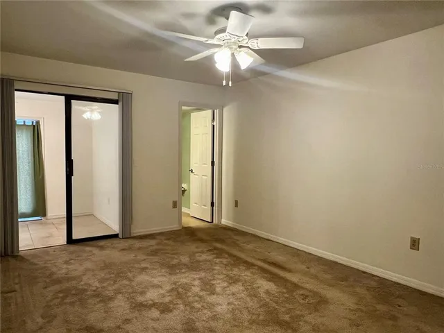 an empty room with fan and windows