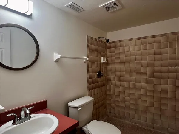 a bathroom with a toilet sink shower and mirror