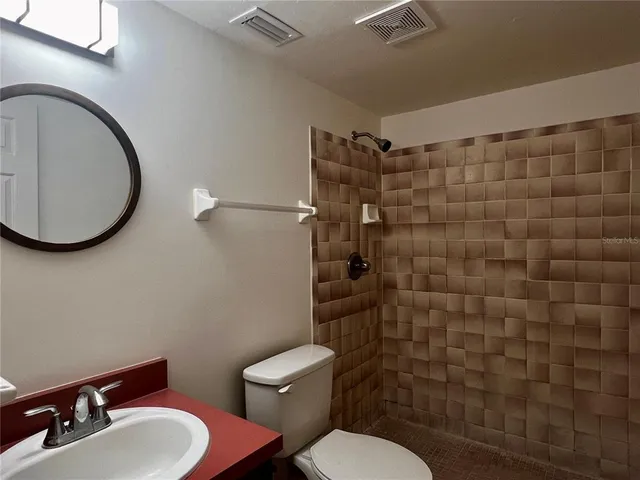 a bathroom with a toilet sink shower and mirror