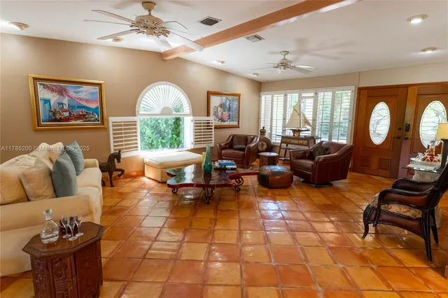 a living room with furniture a fireplace and a large window