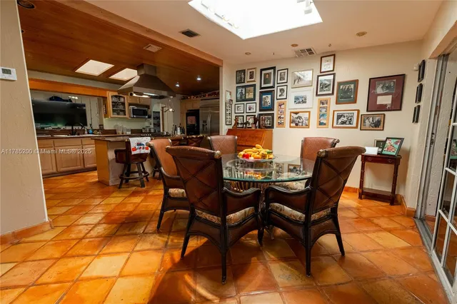 a dining room with stainless steel appliances kitchen island granite countertop a table and chairs
