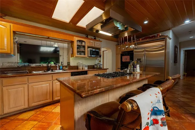 a kitchen with stainless steel appliances granite countertop a sink and a refrigerator