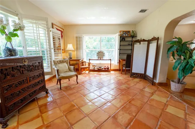 a living room with patio furniture and a floor to ceiling window