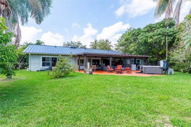 a view of an house with backyard and porch
