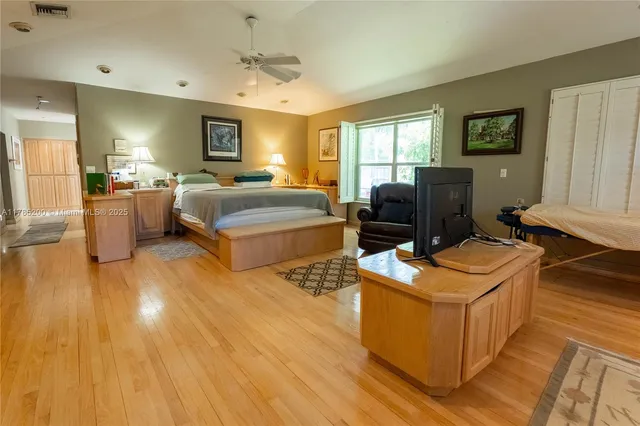 a bedroom with a bed and wooden floor