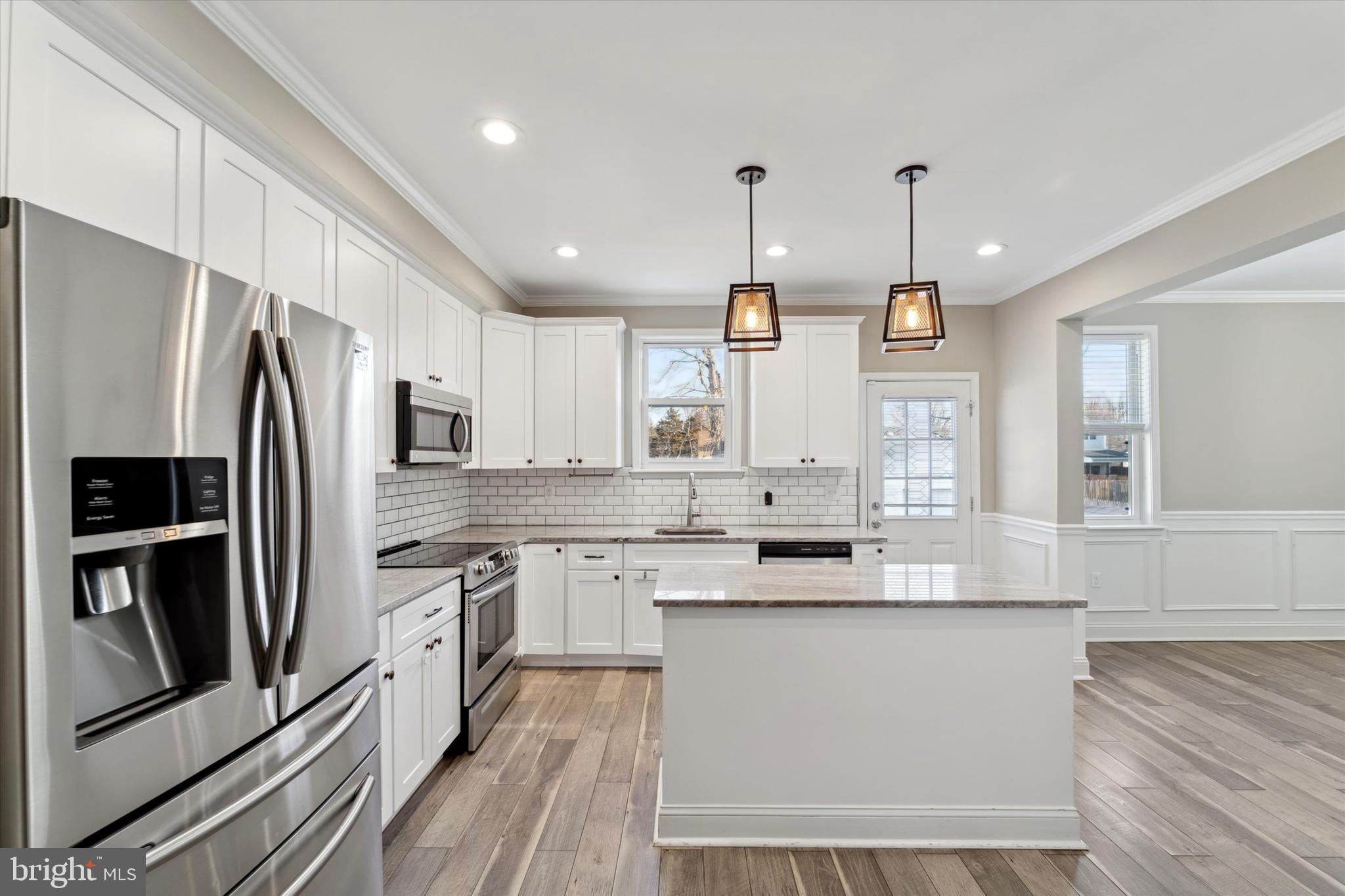 341 Date Street Warminster, PA 18974 - Photo 4 of 33 a large kitchen with stainless steel appliances a large counter top a stove a sink dishwasher a refrigerator and white cabinets with wooden floor