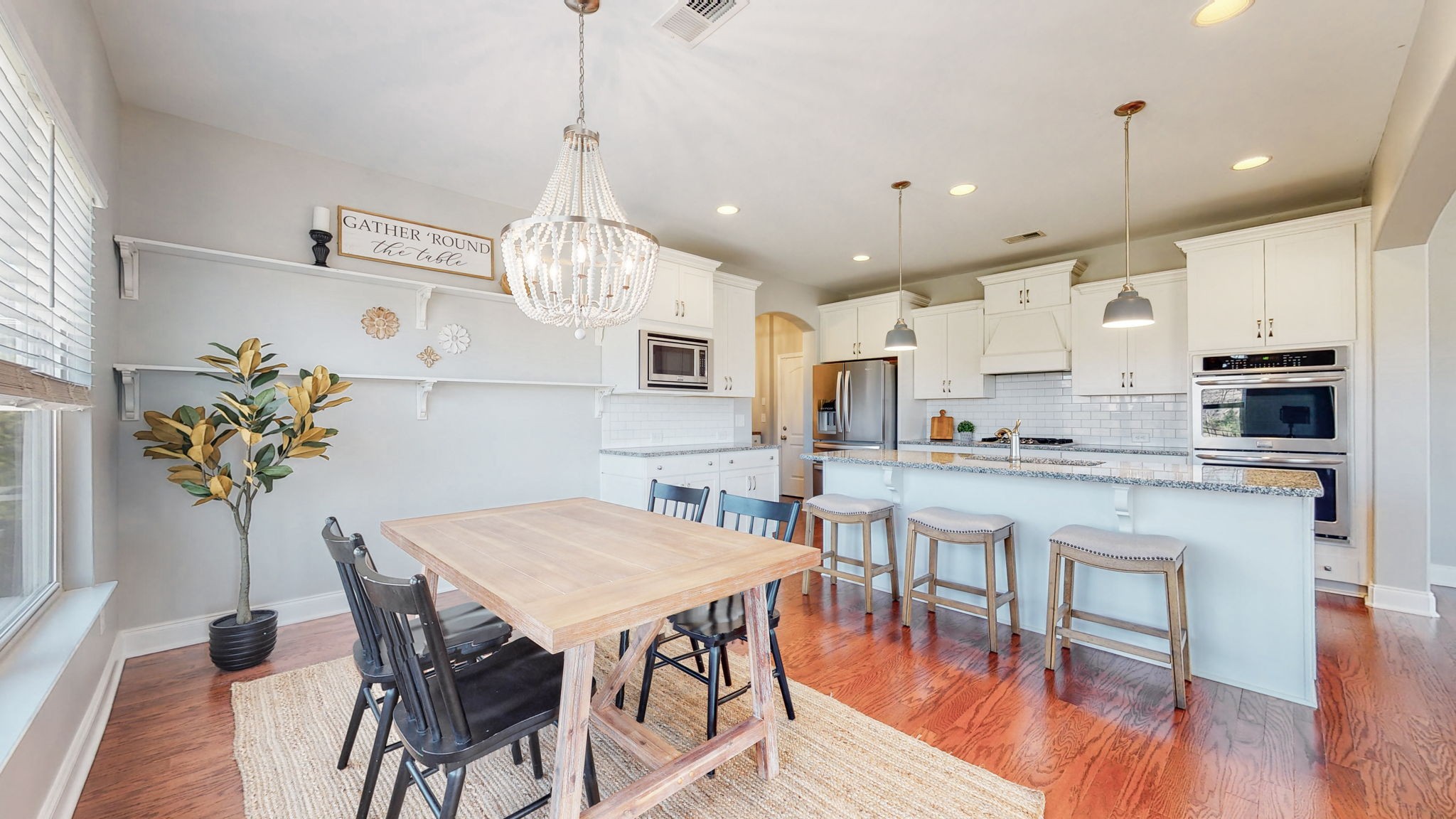 123 Monarchos Drive Gallatin, TN 37066 - Photo 14 of 55 a kitchen with stainless steel appliances granite countertop a dining table chairs and white cabinets