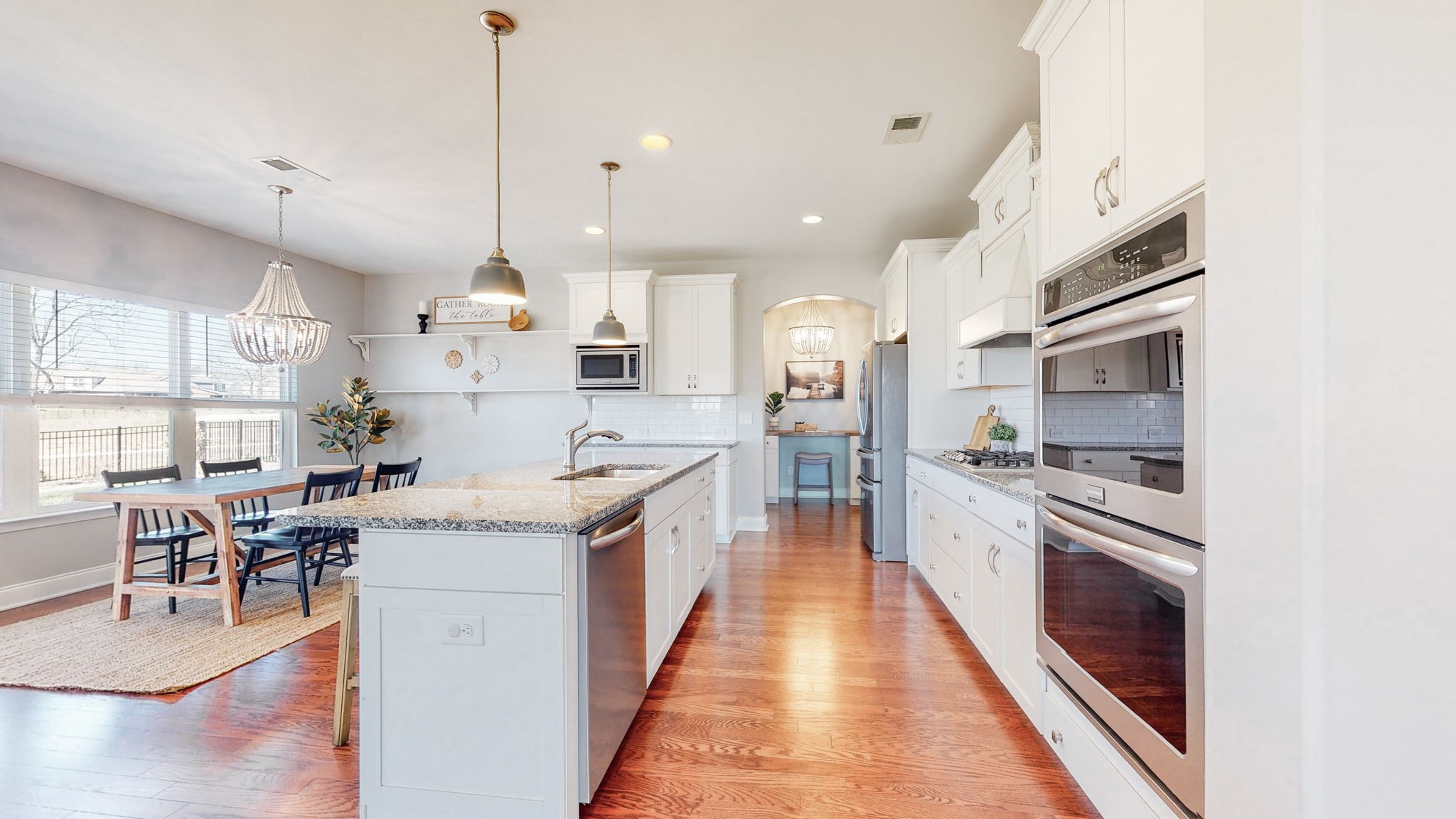 123 Monarchos Drive Gallatin, TN 37066 - Photo 8 of 55 a large kitchen with stainless steel appliances kitchen island granite countertop a large kitchen island a stove a refrigerator a sink dishwasher a dining table and chairs with wooden floor