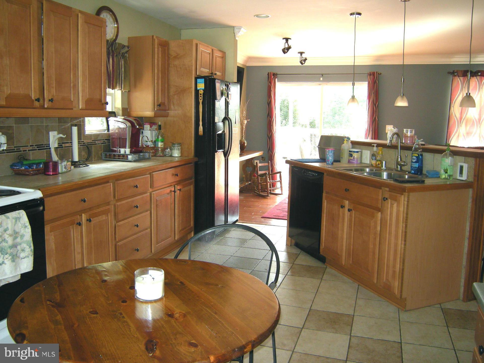 3067 Perch Drive Riva, MD 21140 - Photo 11 of 28 a kitchen with stainless steel appliances kitchen island granite countertop a refrigerator a stove a sink dishwasher with a dining table and chairs
