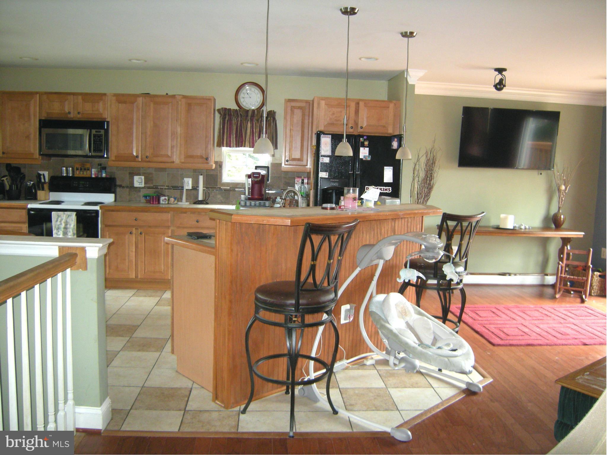 3067 Perch Drive Riva, MD 21140 - Photo 13 of 28 a kitchen with stainless steel appliances kitchen island granite countertop a table and chairs in it