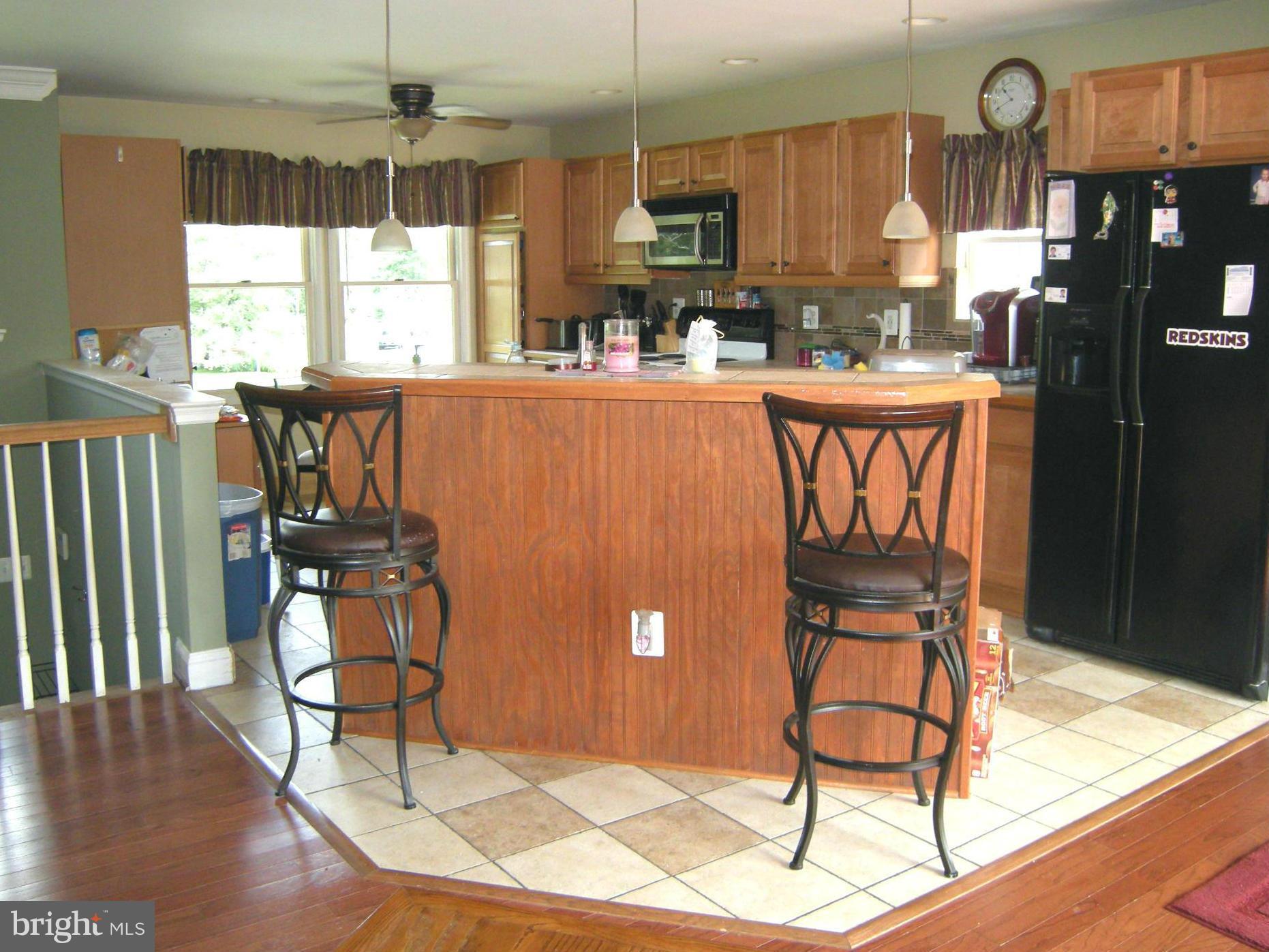 3067 Perch Drive Riva, MD 21140 - Photo 10 of 28 a kitchen with stainless steel appliances granite countertop a sink a stove a dining table and chairs with wooden floor