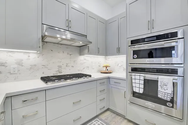 a kitchen with white cabinets and appliances
