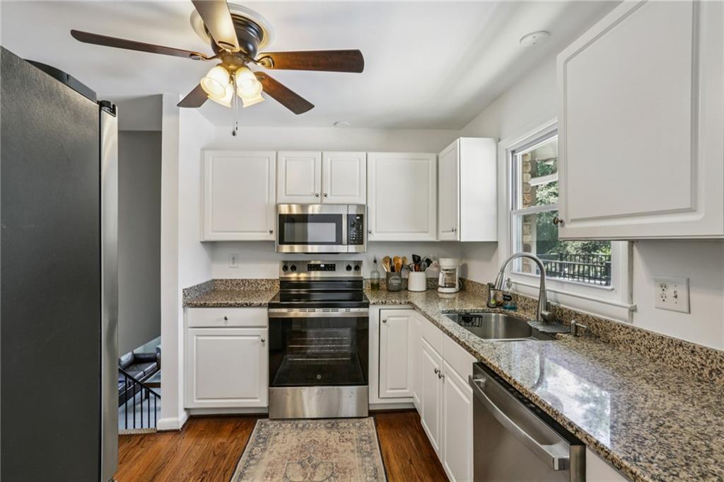 2740 Frontier Trail Atlanta, GA 30341 - Photo 16 of 29 a kitchen with stainless steel appliances granite countertop a sink a stove a refrigerator cabinets and wooden floor