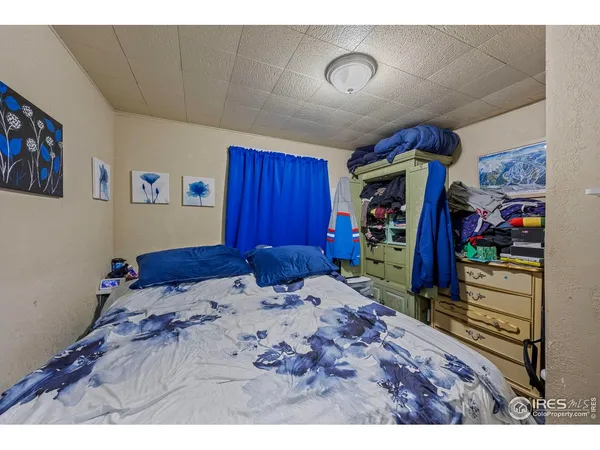 a bed room with a bed and a view of kitchen