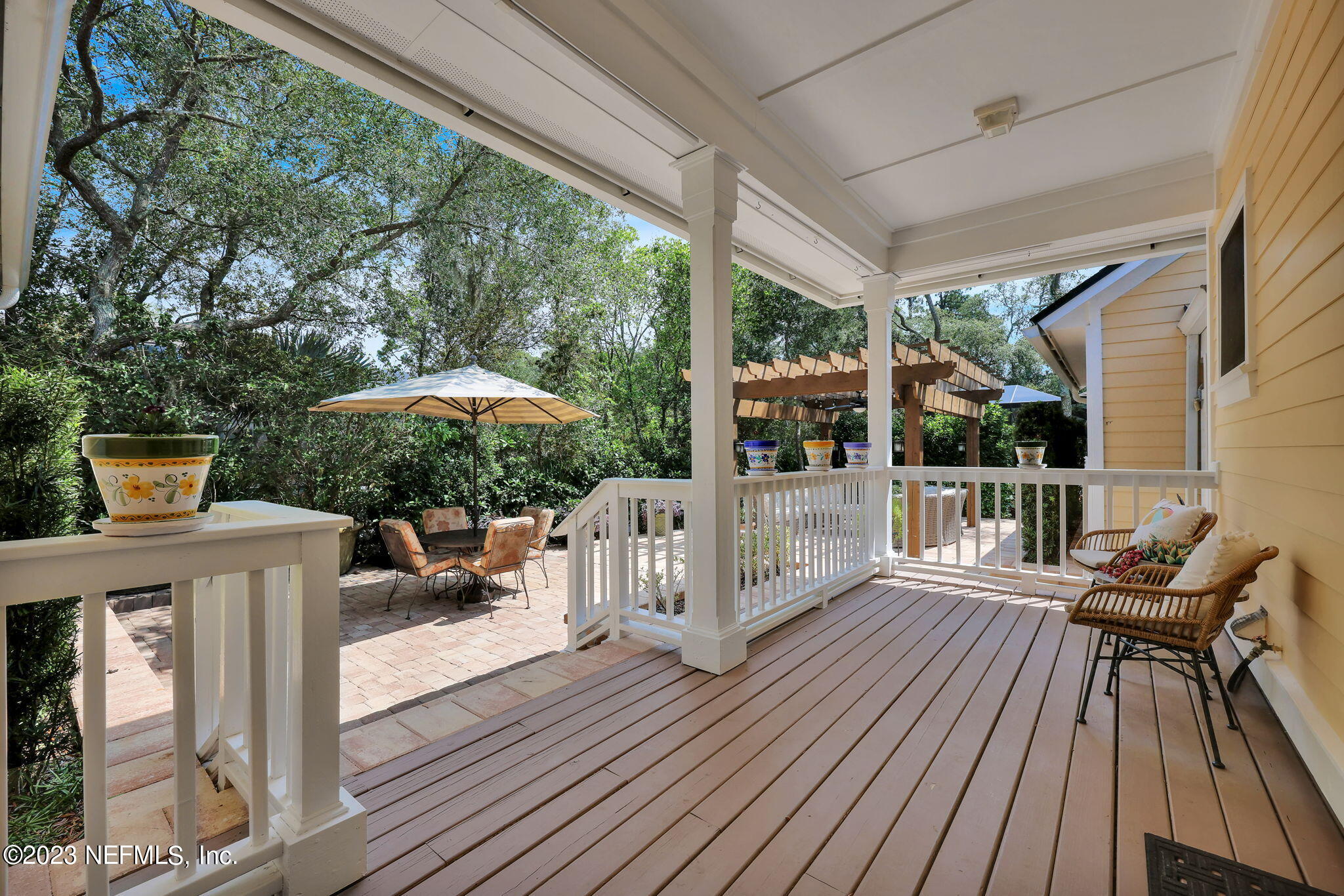 120 Istoria Drive St. Augustine, FL 32095 - Photo 52 of 90 a view of a patio with couches table and chairs under an umbrella with wooden floor