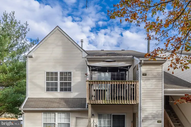 a view of house with a large window and potted plants