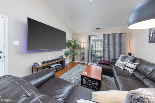 a living room with furniture a flat screen tv and a large window