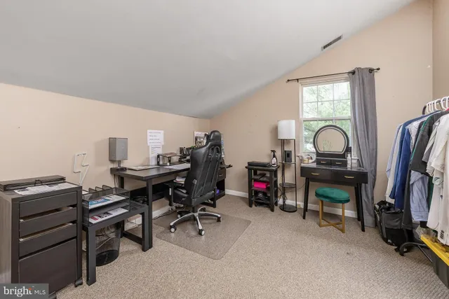 a view of a workspace with furniture and a window
