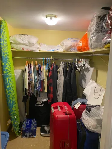 a view of walk in closet with clothes and shoes