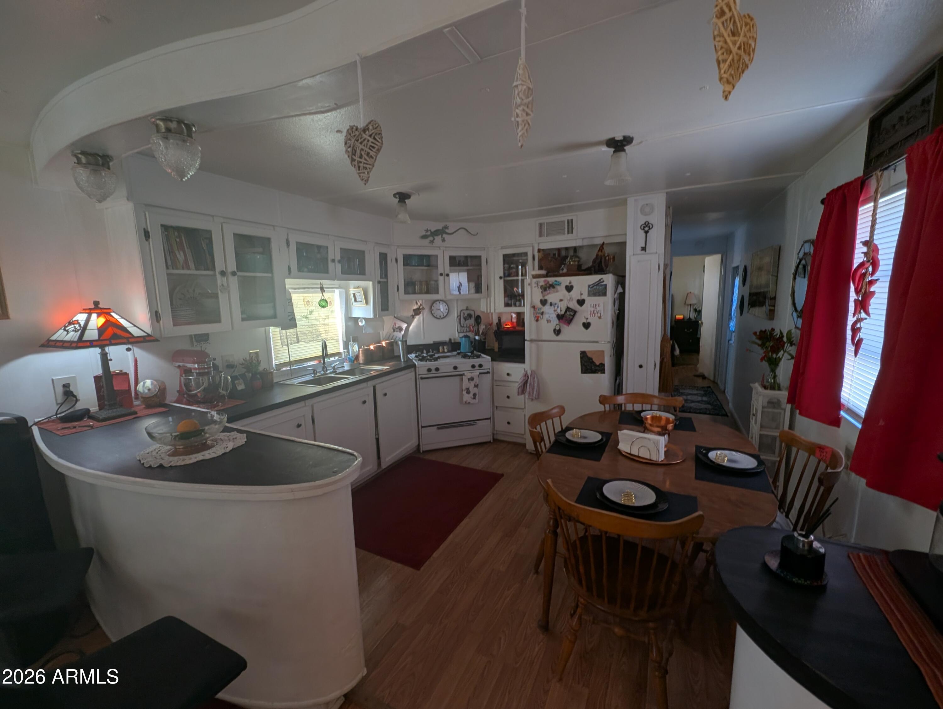 850 West Sieling Loop Bisbee, AZ 85603 - Photo 7 of 11 a kitchen with sink refrigerator dining table and chairs