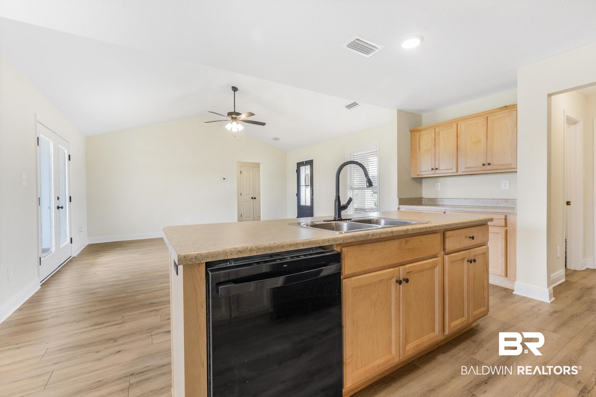 21580 Talbot Lane Robertsdale, AL 36567 - Photo 14 of 25 Kitchen featuring light brown cabinets, black dishwasher, light wood-style floors, lofted ceiling, and a kitchen island with sink