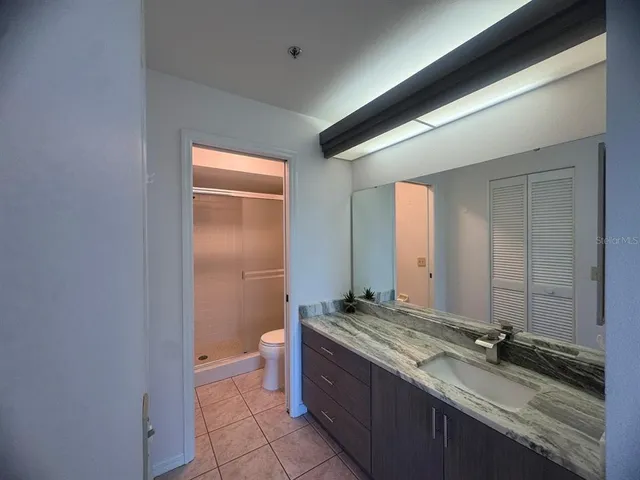 a bathroom with a granite countertop sink and a mirror