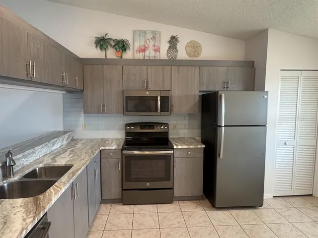 a kitchen with a refrigerator sink and cabinets