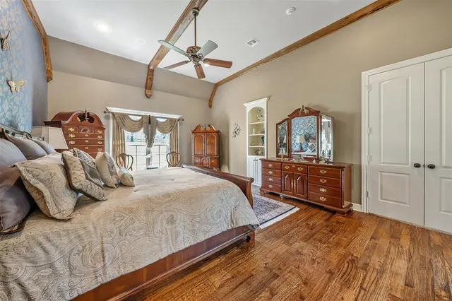 a bedroom with a bed and a dresser with mirror