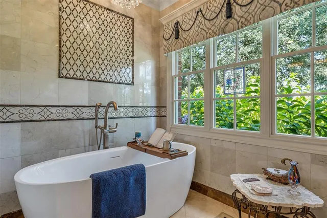 a white bath tub sitting in a bathroom next to a window