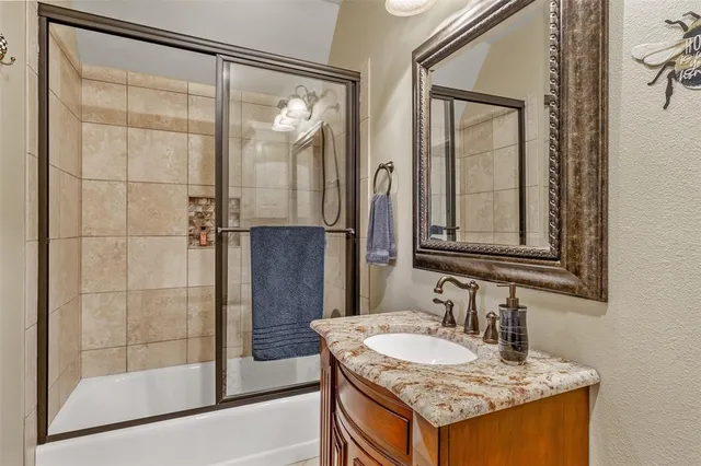 a bathroom with a granite countertop sink and a mirror