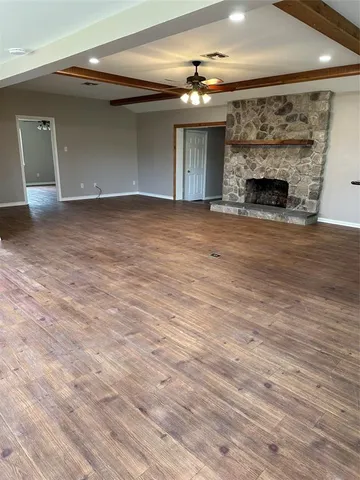 an empty room with wooden floor and fireplace