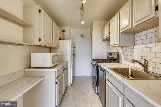 a kitchen with a sink stove top oven and cabinets