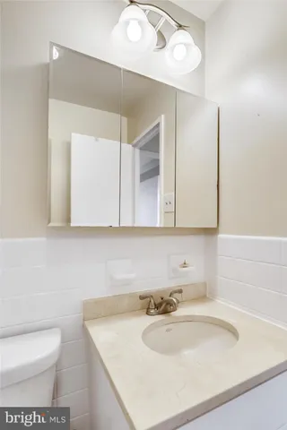 a bathroom with a sink toilet vanity and mirror